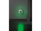 A green glowing night light plugged into a wall socket, illuminating the floor.