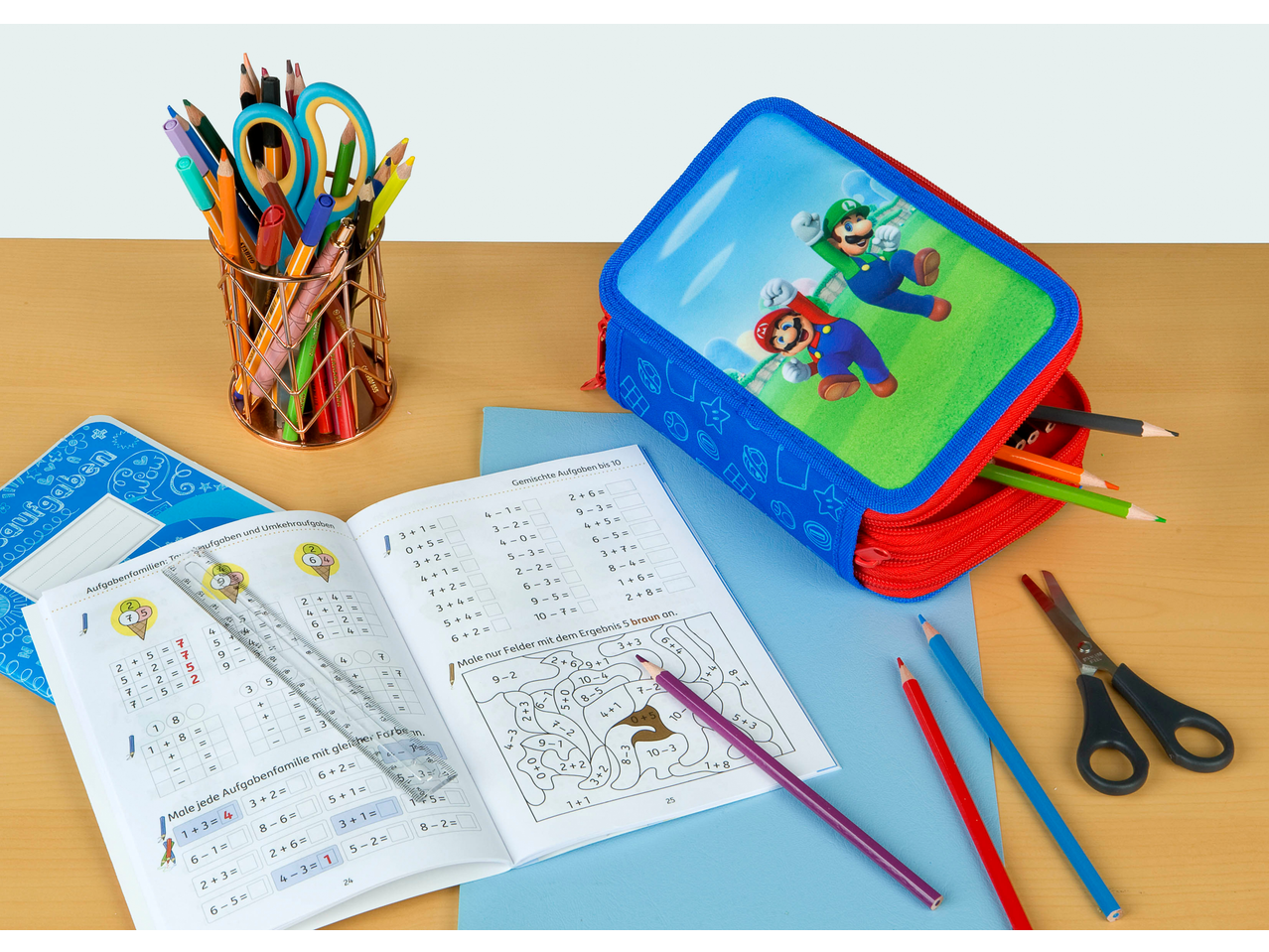 Mario and Luigi pencil case with school supplies and math workbooks on a wooden desk.
