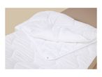 White quilted duvet with snap fasteners on a beige bed