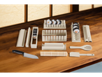 Kit de sushi Silvercrest com moldes, esteira, faca e utensílios sobre uma mesa de madeira.