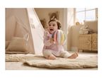 Happy baby playing with a colorful soft ball on a quilted mat in a teepee tent.