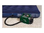 An air pump inflating a blue air mattress on a shaggy rug.