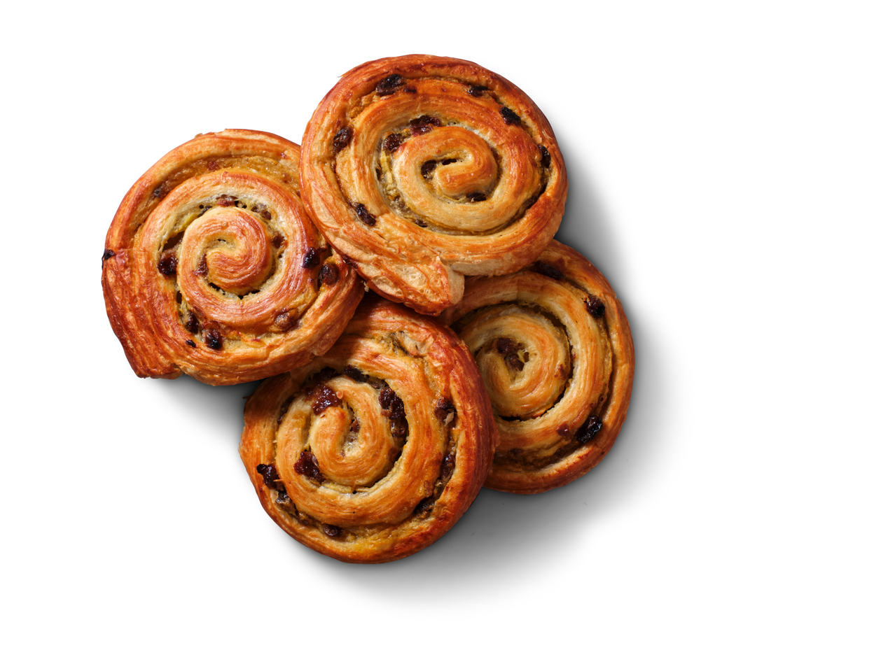 Četras zeltaini brūnas rozīņu gliemežmaizītes, konditorejas izstrādājumi ar rozīnēm, sakrautas uz balta fona.