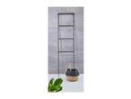 Black metal towel ladder with a woven basket and a green plant.