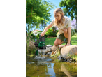 Woman using a submersible pump to clear water from a garden pond.