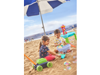 Two children playing with a Lupilu Sand and Water Activity Table and other toys on a sandy beach.