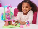 A young girl playing with a Gabby's Dollhouse Purrfect Dollhouse playset.