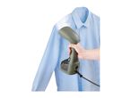A hand holding a garment steamer to steam a light blue shirt.