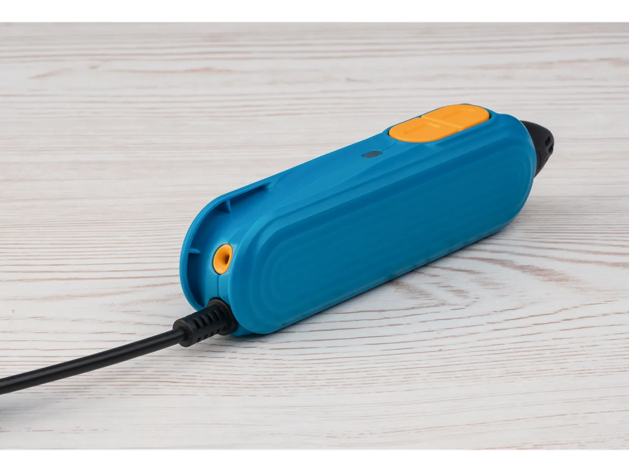 Plava CRELANDO® 3D olovka sa narandžastim dugmadima i crnim kablom na drvenom stolu.