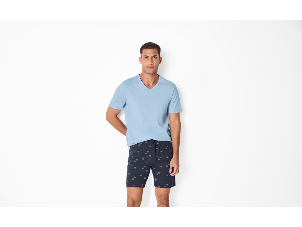 Bărbat în pijama ESMARA MEN, tricou albastru deschis cu decolteu în V și pantaloni scurți cu model.