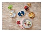 Overhead shot of coffee ice cream tub, scoops on a plate, and a dessert with berries.
