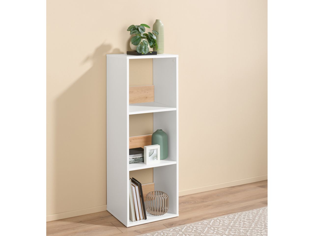 White and wood-look Shelving Unit With 3 Compartmens with decorative items in a room with a light wall.