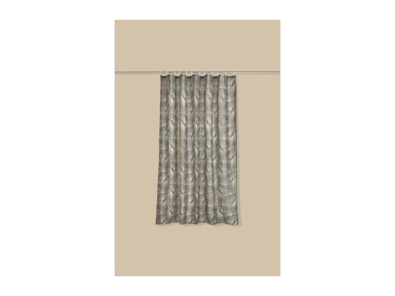 Grey shower curtain with a white leaf pattern, hanging on a silver rod.