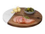 Round wooden and marble serving board with sliced cured meat, cheese cubes, and green olives.