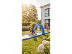 Children playing on a Lupilu water slide with a shark arch in a sunny garden.