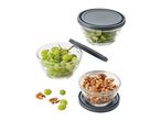 Glass storage bowls with gray lids, filled with grapes and walnuts.