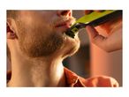 Man trimming his beard with a Philips OneBlade electric shaver.