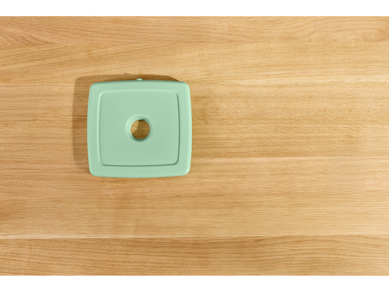 Tampa quadrada Silvercrest® em verde menta sobre uma mesa de madeira