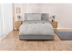 A grey upholstered bed with a beige and grey geometric duvet cover and pillows sits in a minimalist bedroom.