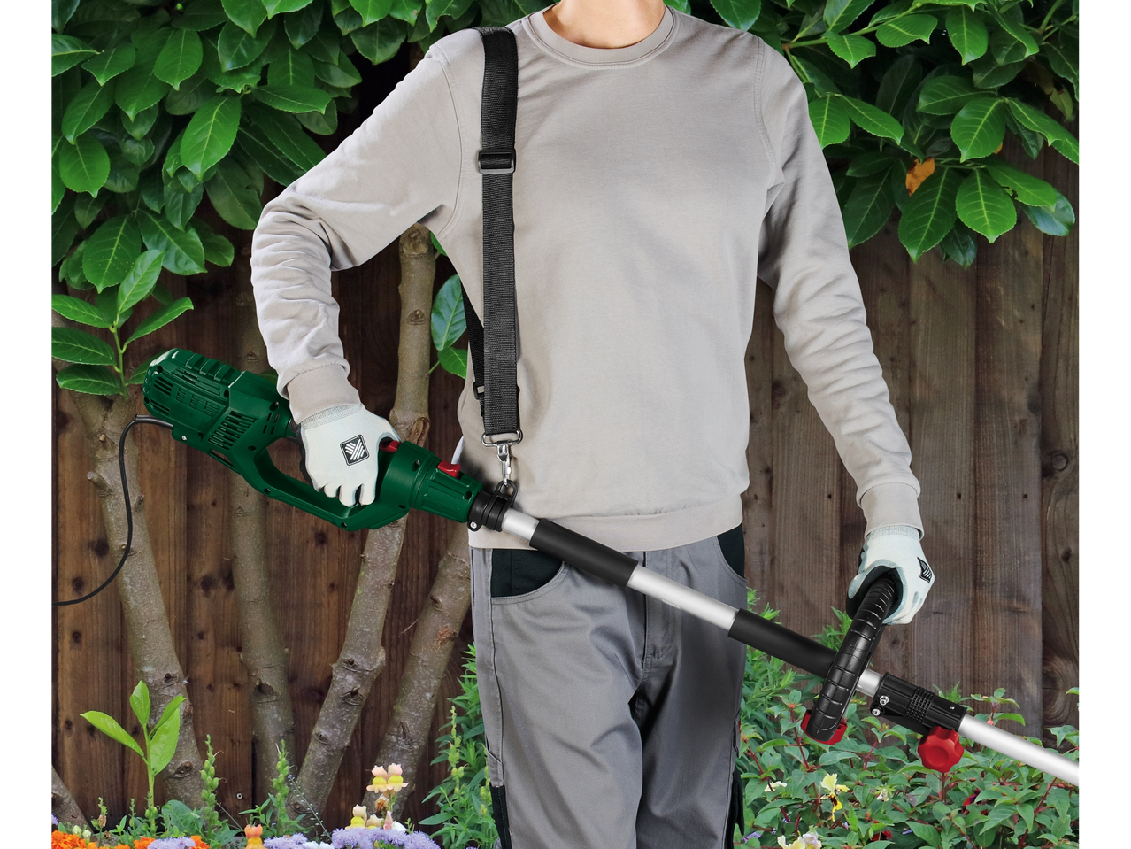 Um homem segura um aparador de grama Einhell verde sem fio.