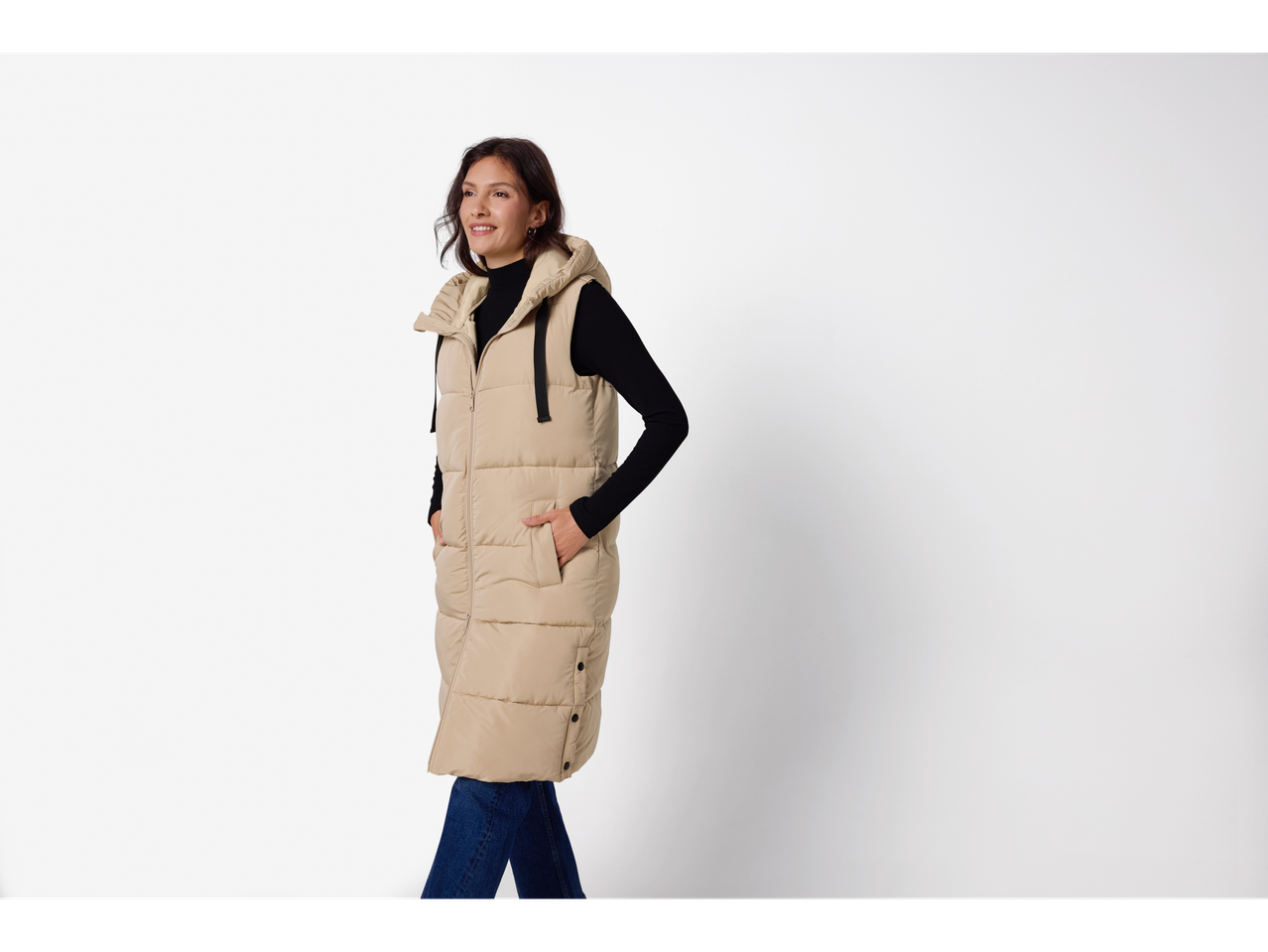 Esmara® Ladies' Longline Padded Gilet in beige, worn by a woman with a black turtleneck and jeans.
