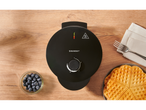 SILVERCREST waffle maker with waffles, blueberries, fork, and napkin on a wooden table.