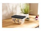 Pasta salad in a rectangular food container with a black lid on a wooden surface.
