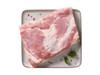 Frisches Schweinefleisch auf einer grauen Platte mit Petersilie und rosa Pfeffer.