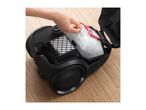 A hand removing a dust bag from a black vacuum cleaner, with a filter visible.