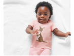 Baby in pink kangaroo jumpsuit, newborn clothes.