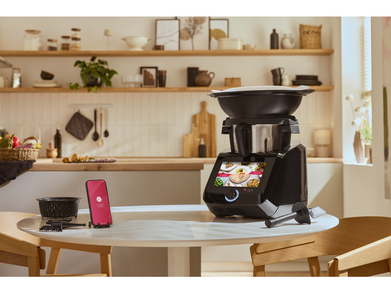 SILVERCREST KITCHEN TOOLS Monsieur Cuisine smart und Smartphone auf einem Küchentisch.
