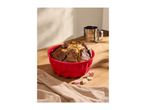 A freshly baked marble cake in a red silicone bundt pan, with a flour sifter in the background.