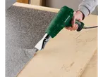 O persoană folosește un pistol cu aer cald Parkside pentru a lucra cu laminat.