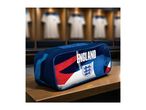 Blue sports bag with 'ENGLAND' text and a crest, on a wooden bench in a locker room.