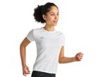 A woman in a white Kalenji running shirt jogs.