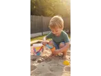 Lupilu Sand Toys: A child plays in a sandbox, filling an orange cone with sand.