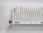 Fehér radiátorra szerelt ventilátorok és egy hőmérséklet-érzékelő