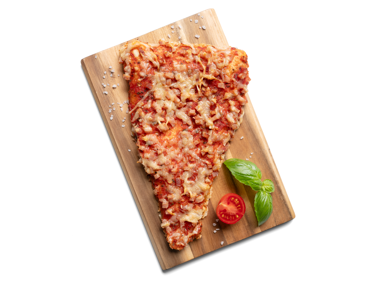 Egy szelet sonkás pizza vágódeszkán bazsalikommal és paradicsommal.