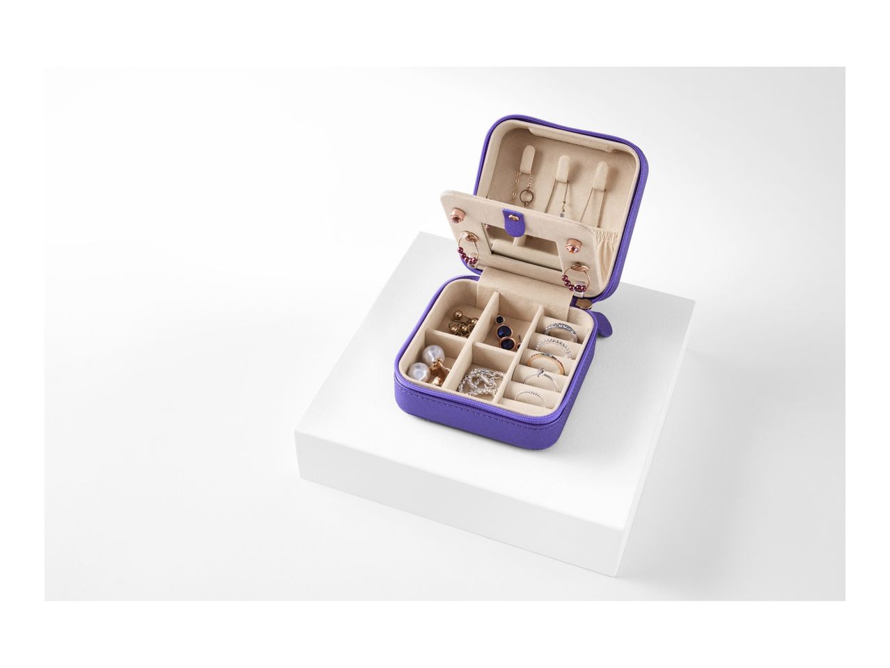 A purple travel jewelry case with compartments open, showcasing its interior organization.