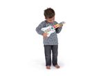 A young boy playing a white and wooden toy guitar with colorful animal buttons.