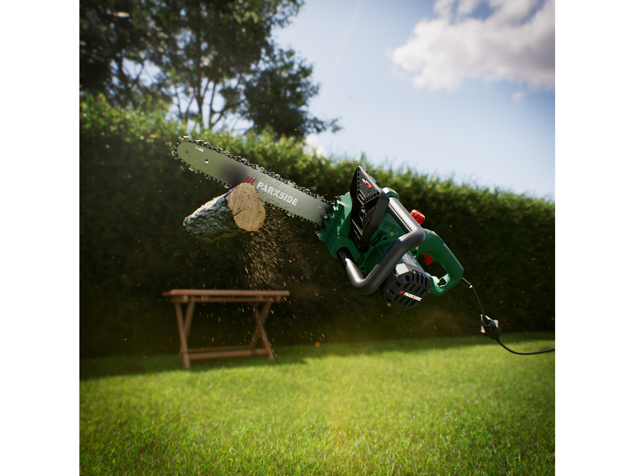 Electric chainsaw cutting a log, with sawdust flying, in a sunny garden.