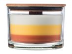 A layered candle in a glass jar with a wooden lid, featuring white, yellow, and orange layers.
