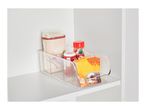 Clear storage bin with rice, spices, and baking mix on a white shelf.