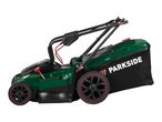 Green and black lawnmower with a grass collection bag and red accents on a white background.