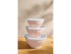 Three pink mixing bowls with white lids, stacked on a wooden table.