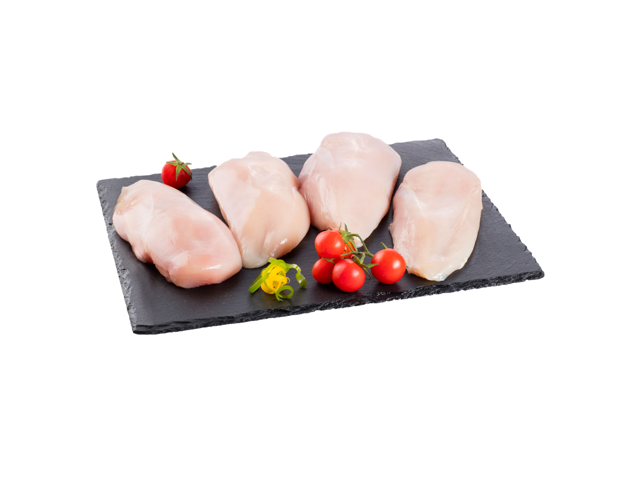 Sveža pileća prsa na crnoj ploči sa čeri paradajzom i ukrasima.