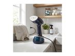 A handheld garment steamer on a kitchen counter next to a linen shirt, with laundry supplies on shelves.