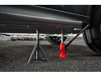 A car is lifted by a red hydraulic jack and supported by a grey jack stand.