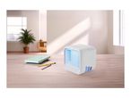 Portable air cooler on a wooden desk with notebooks and pens in a bright room.