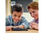 A boy and his mom look at a LEGO Mercedes-AMG Petronas Formula One Team car.